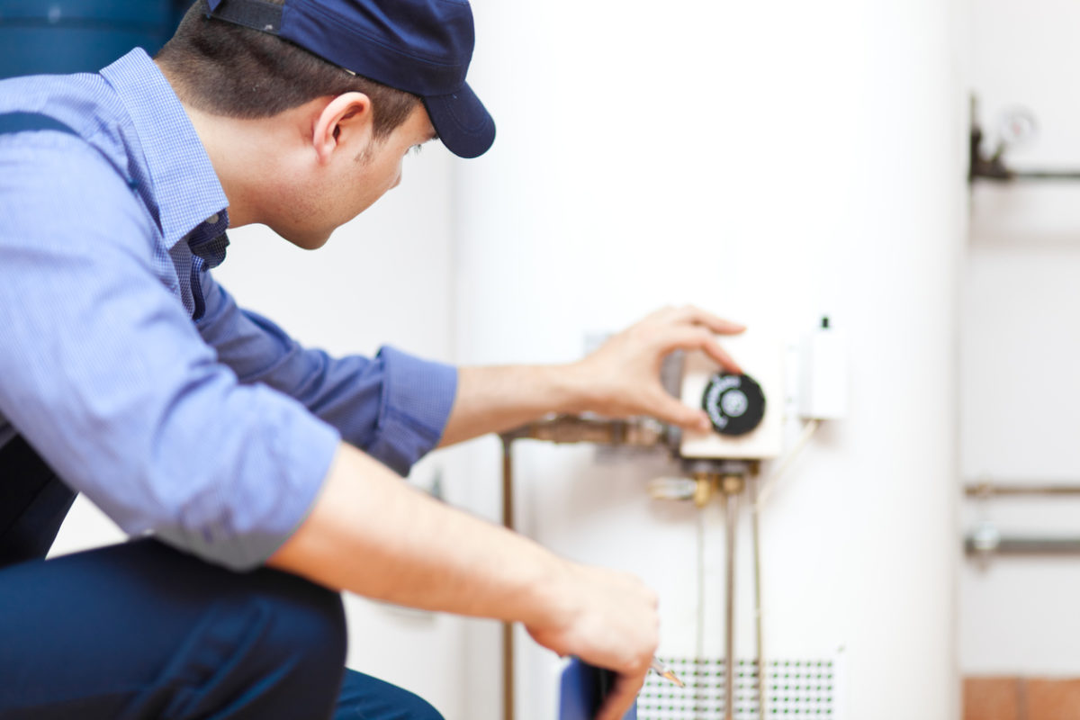 A plumber checking a water heater after a maintenance appointment