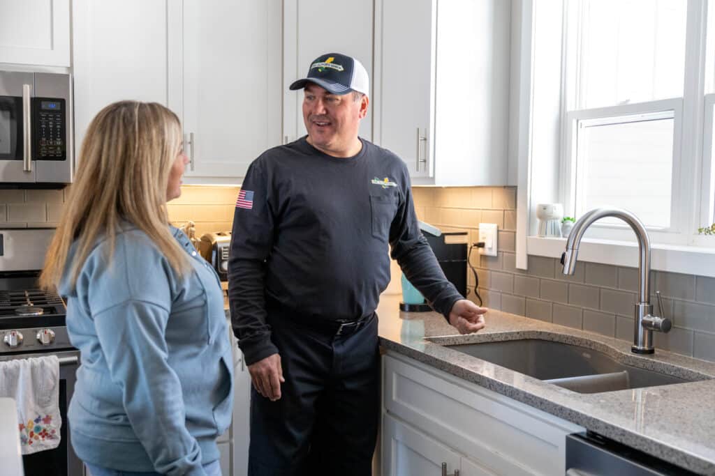Verne & Ellsworth Hann plumber speaking with a homeowner in their kitchen