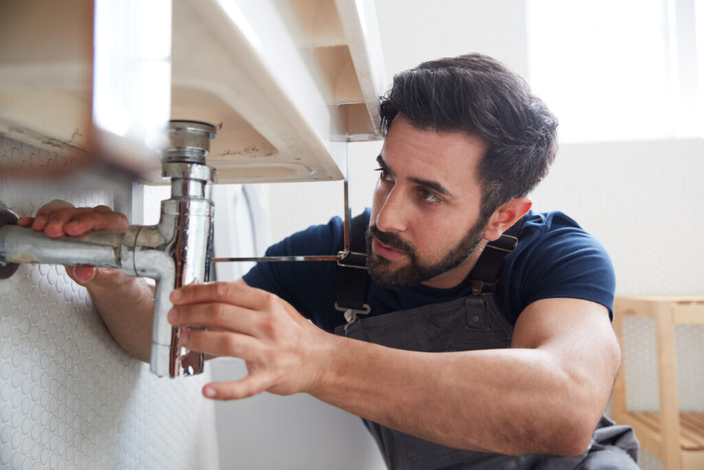 Plumber fixing bathroom sink